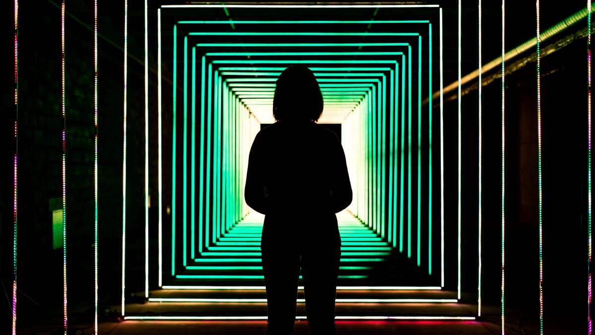 Shadow of a woman standing under fluorecent light - Photo by Bit Cloud on Unsplash