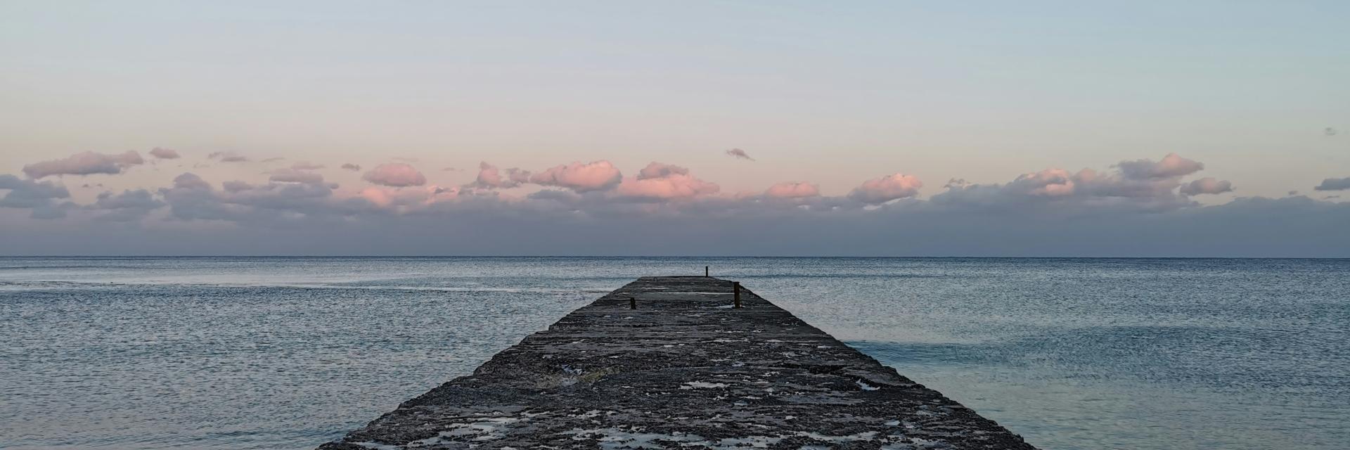 Gray concrete dock on sea during daytime. Credit photo: by Dmytro Lysenko on Unsplash