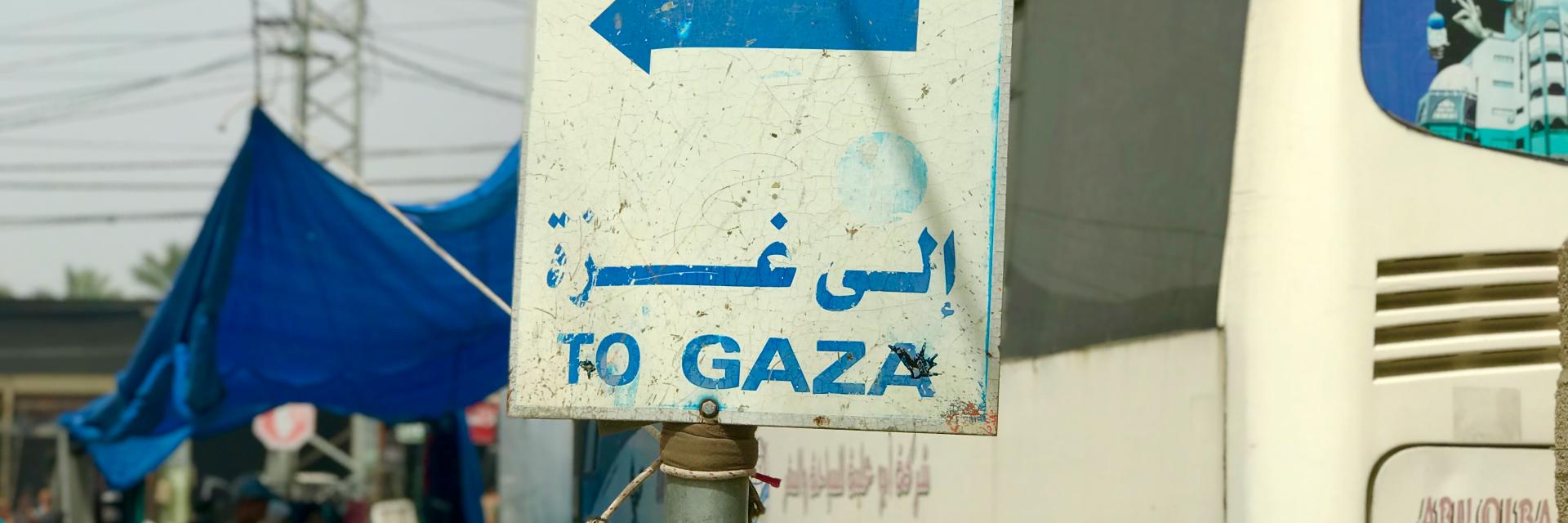 A white bus parked next to a sign that reads 'To Gaza' | © Emad El Byed, Unsplash