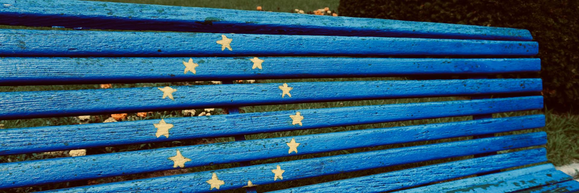 Blue bench with yellow stars painted on it. Photo by Azzedine Rouichi on Unsplash