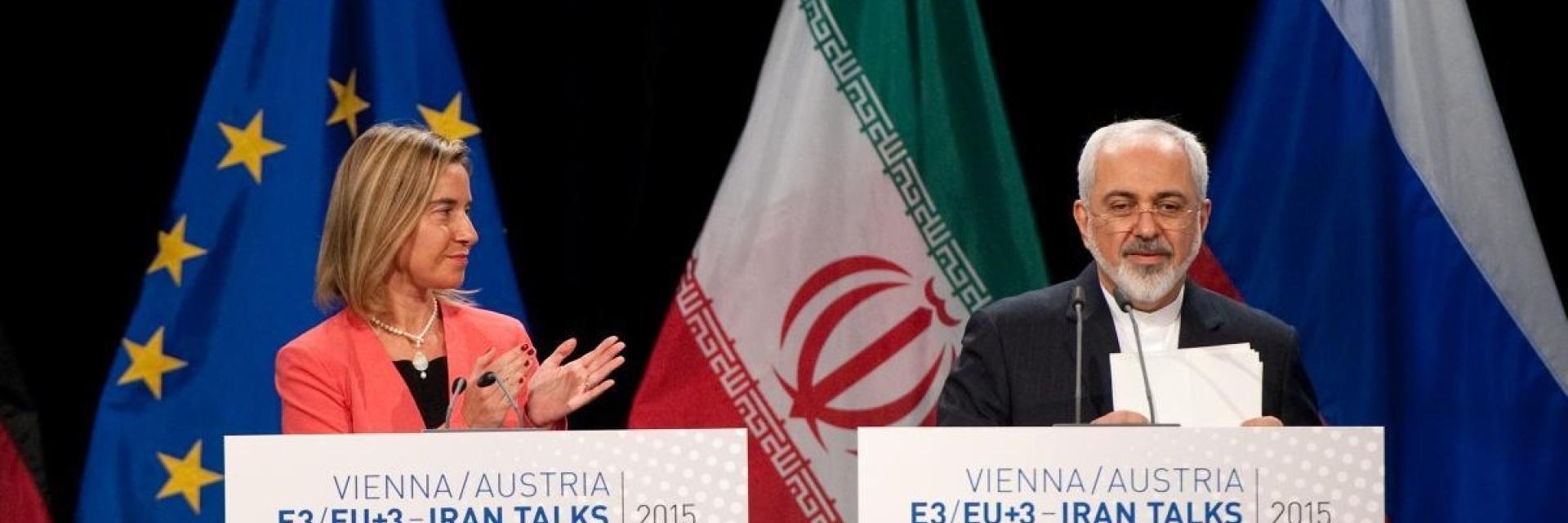 Mohammed Javad Zarif, on the right and Federica Mogherini, applauding on stage in front of EU and Iran flags. Credit photo: European Union 20155