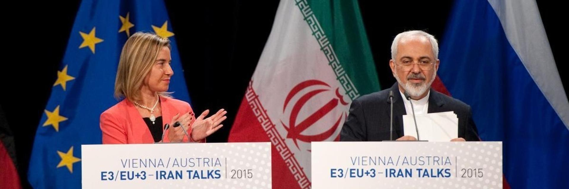 Mohammed Javad Zarif, on the right and Federica Mogherini, applauding on stage in front of EU and Iran flags. Credit photo: European Union 20155