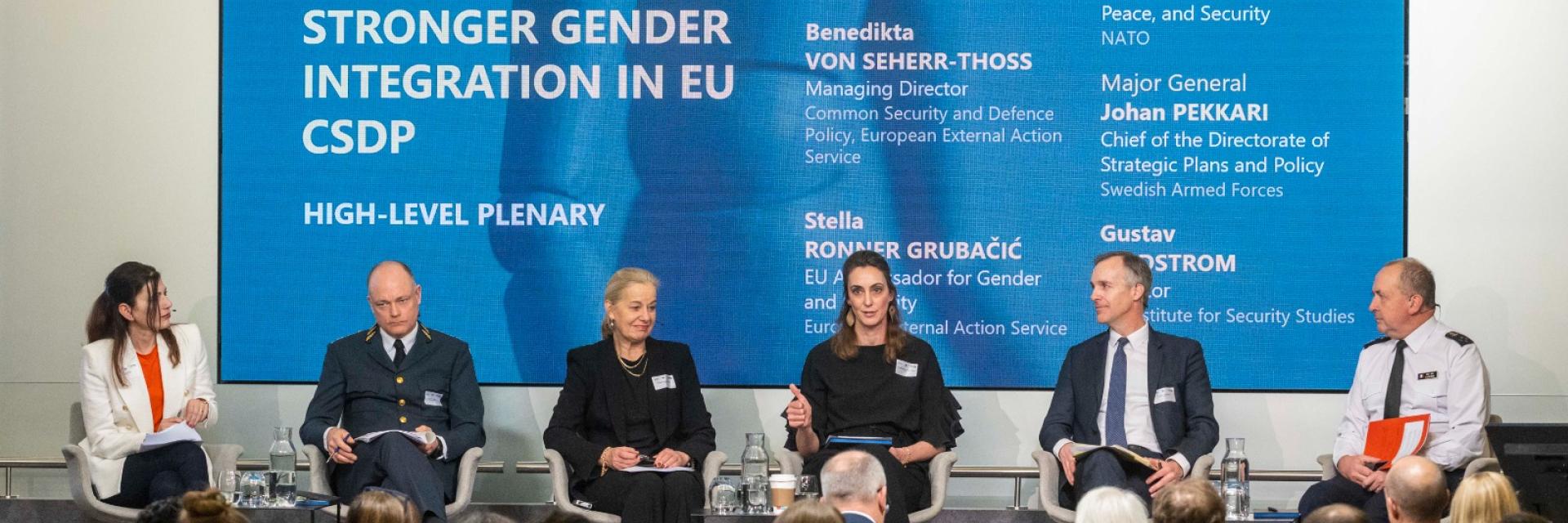 Panel members on a stage with background displaying the theme of the seminar ©EUISS