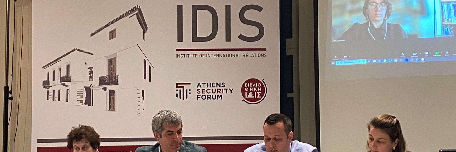 Panel members sitting at tables with microphones 