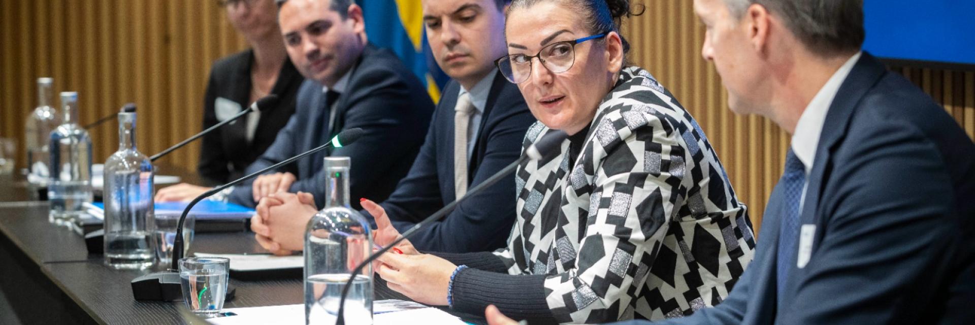 Panel members on a stage with background displaying the theme of the seminar ©EUISS