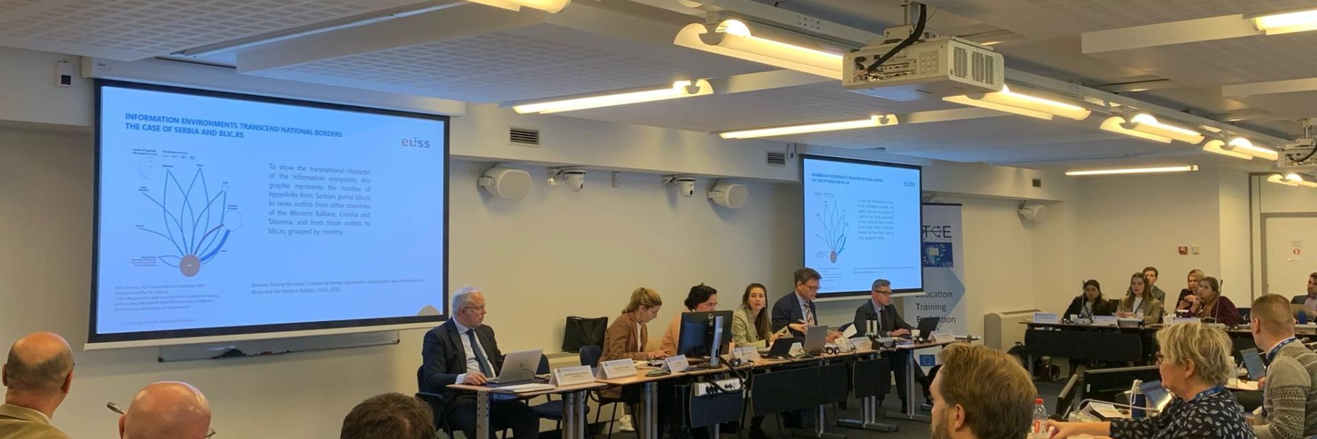 Participants around a table engaged in discussion © EUISS