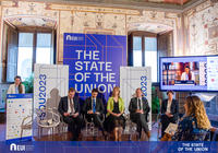 Speaker at podium and panellists sitting on chairs in front of banners with the name of the conference © EUI
