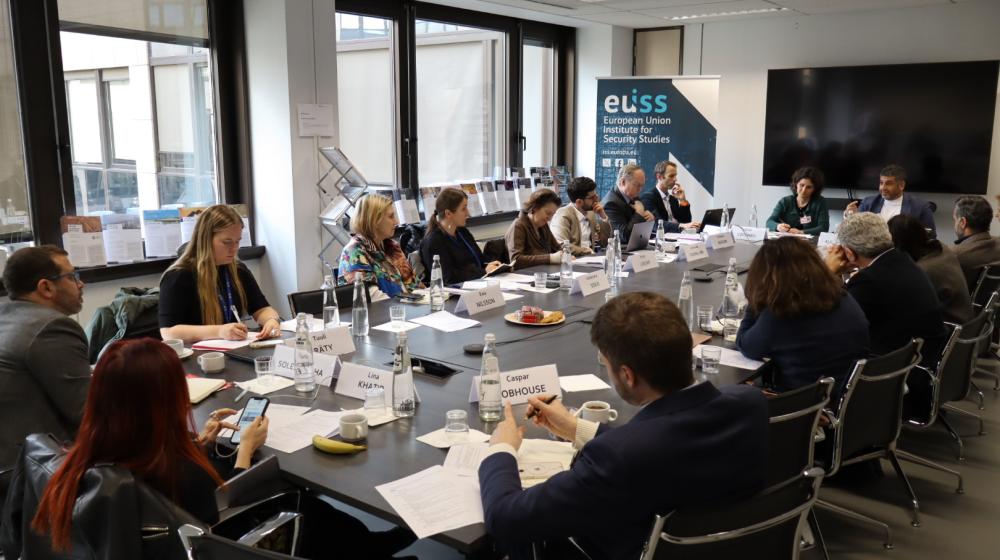 Participants to workshop sitting around table. Credit: EUISS