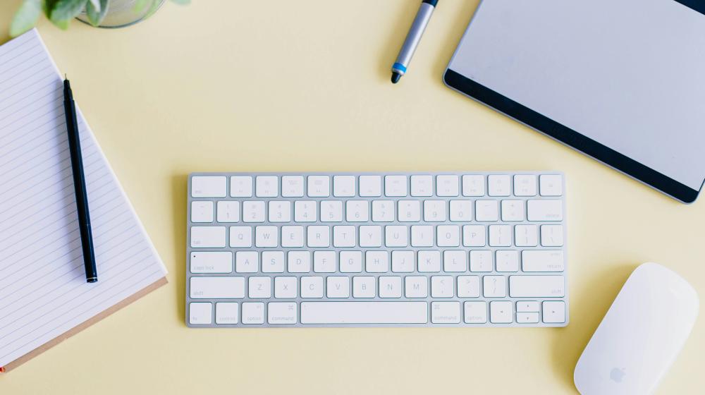 keyboard, laptop, mouse and pen on a desk. Photo by Amy Hirschi on Unsplash