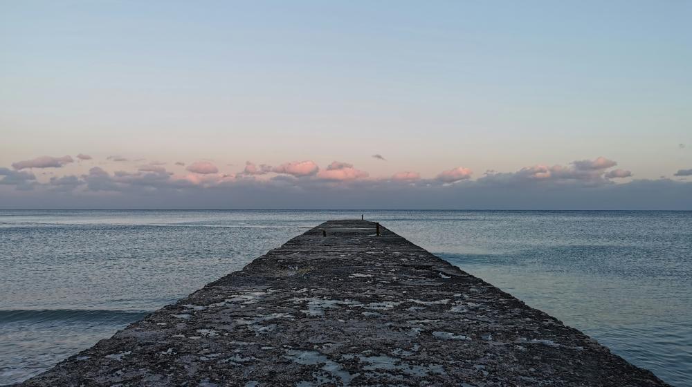 Gray concrete dock on sea during daytime. Credit photo: by Dmytro Lysenko on Unsplash