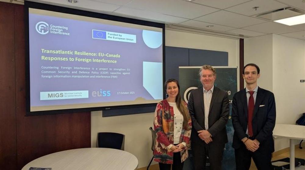 3 participants to the roundtable standing in front of screen with title of discussion. Credit photo: JULIAN HABER-MIGS