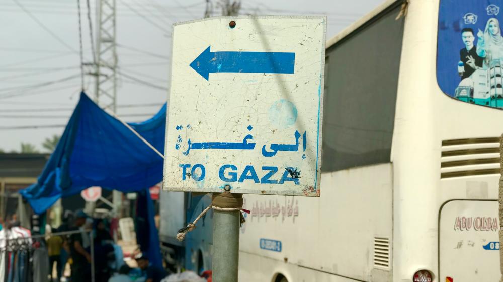 A white bus parked next to a sign that reads 'To Gaza' | © Emad El Byed, Unsplash