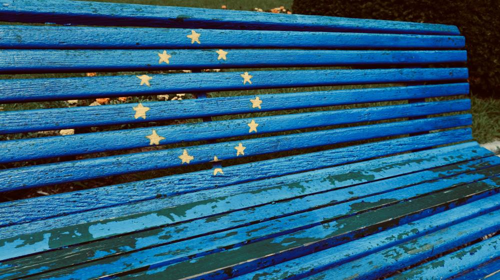 Blue bench with yellow stars painted on it. Photo by Azzedine Rouichi on Unsplash