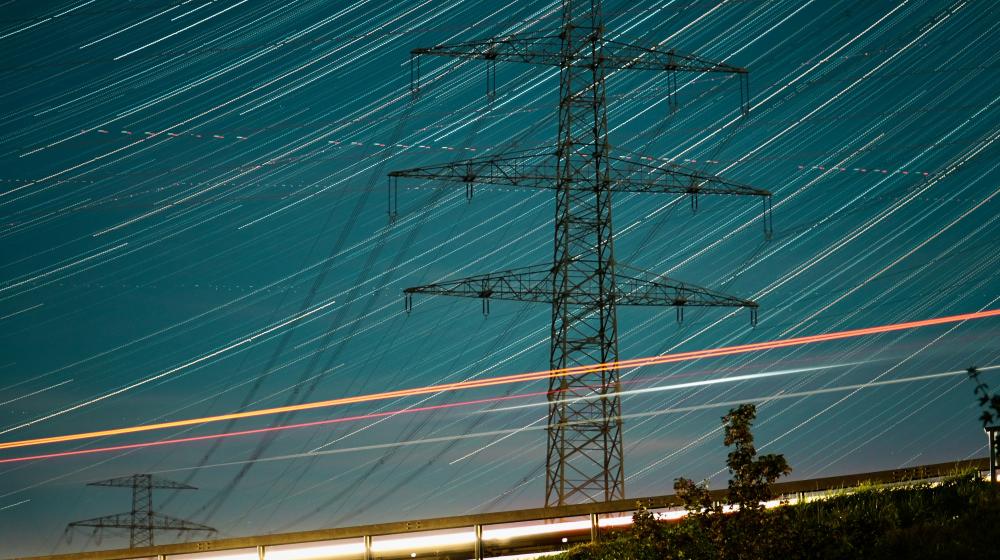 A high voltage power line at night with long exposure. Photo by Viva Zhang on Unsplash