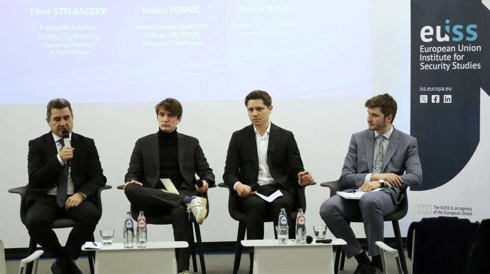 Four men sitting in front of a screen with the name of the event next to EUISS banner. One man is speaking in a microphone. Credit photo: EUISS