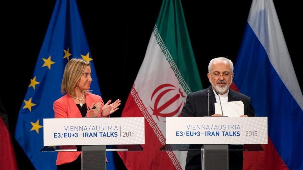 Mohammed Javad Zarif, on the right and Federica Mogherini, applauding on stage in front of EU and Iran flags. Credit photo: European Union 20155