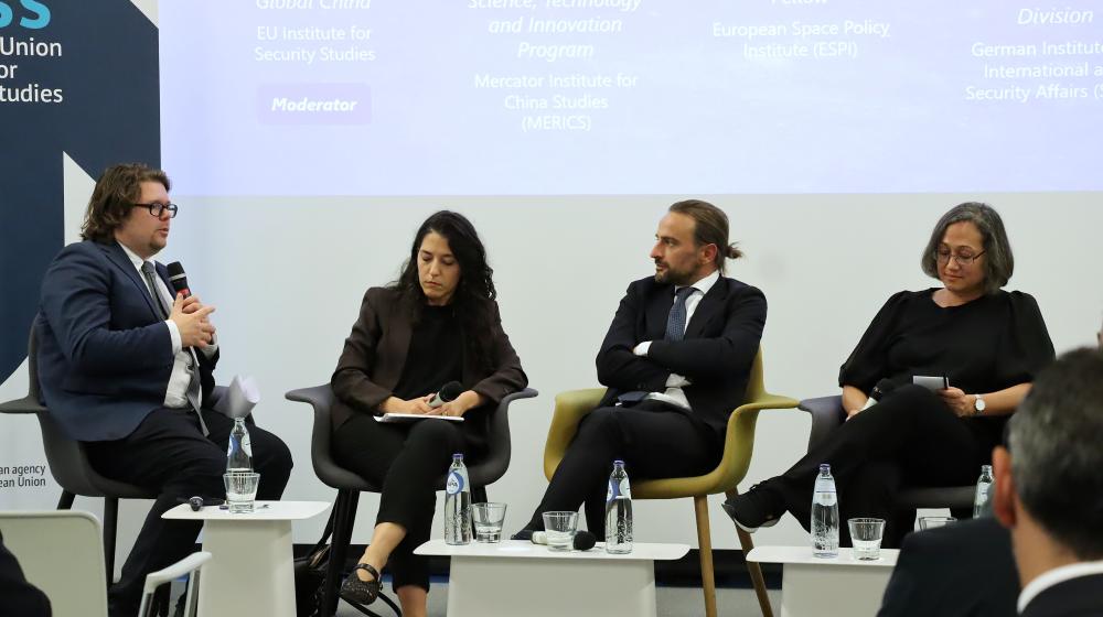 2 women and 2 men sitting on stage. One man is speaking on a microphone. Credit photo: EUISS 