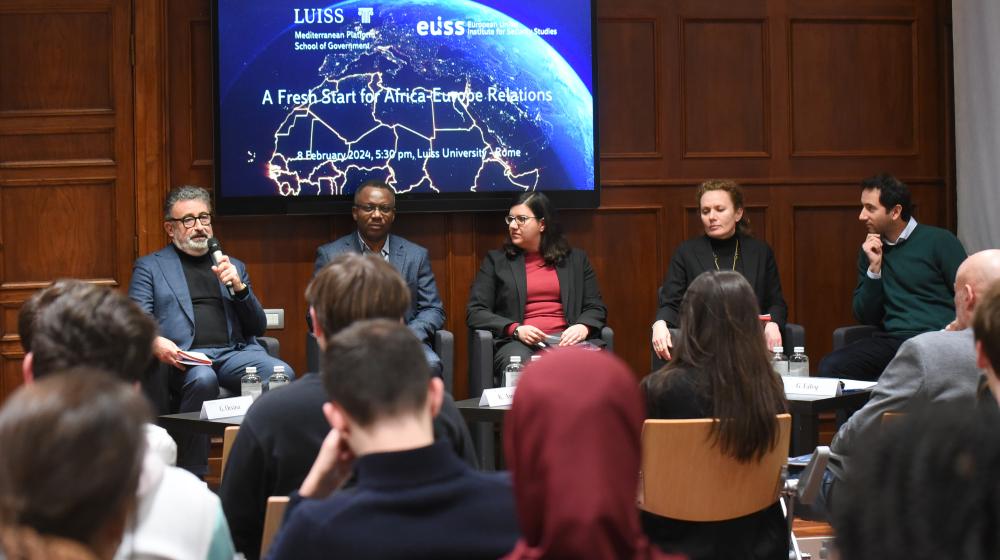 Speakers of the event (3 men, 2 women) sitting in front of an audience © LUISS
