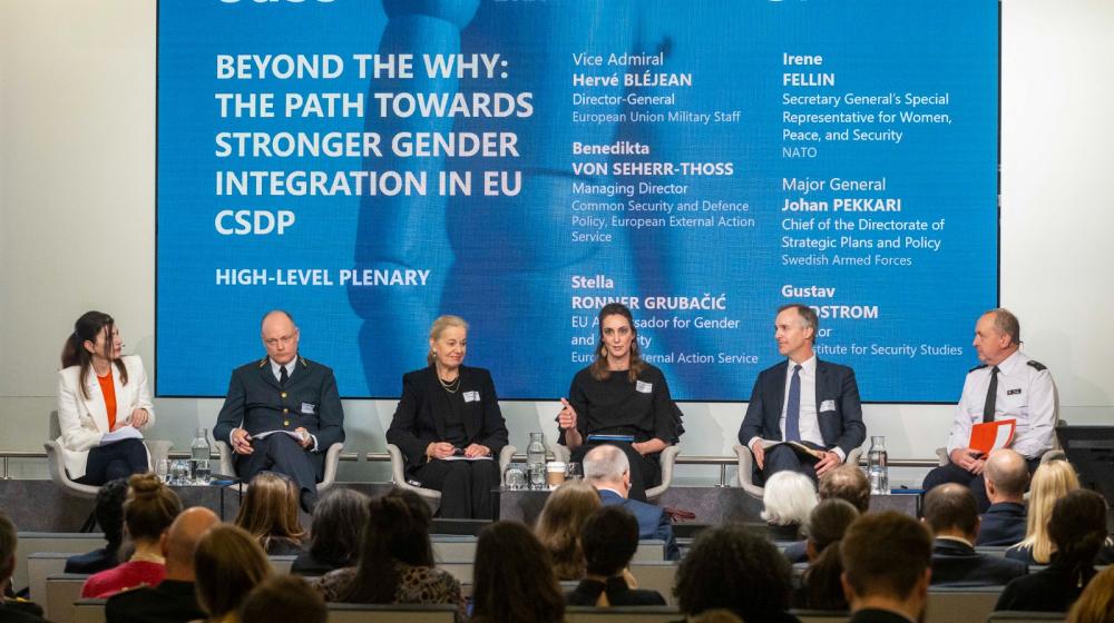 Panel members on a stage with background displaying the theme of the seminar ©EUISS